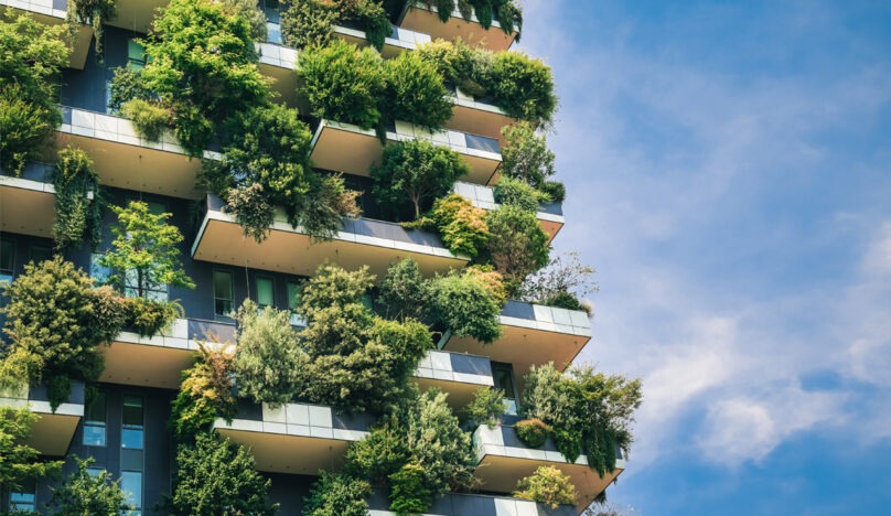 A tall building with plants on balconies